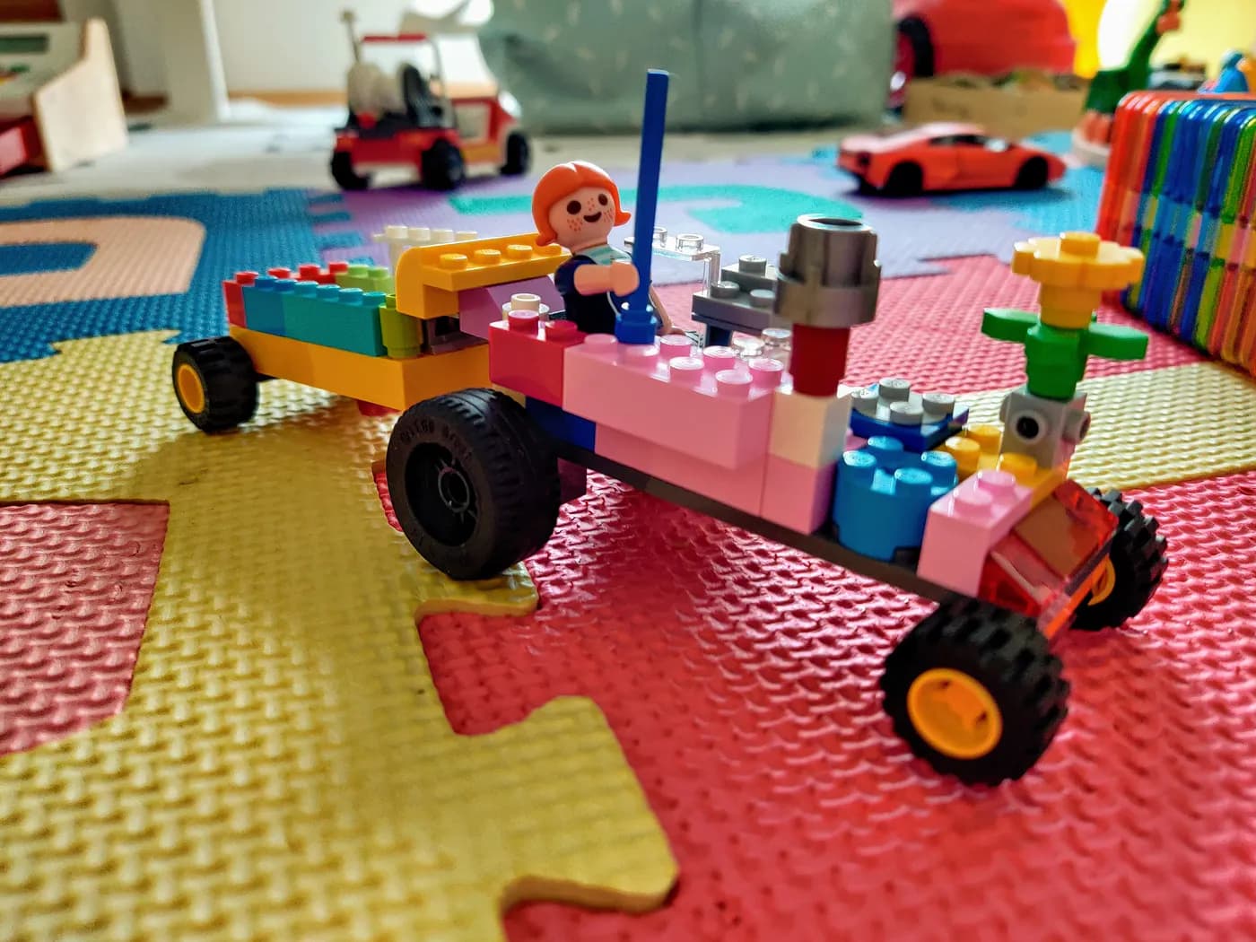 Colorful toy vehicle built from blocks on a foam mat